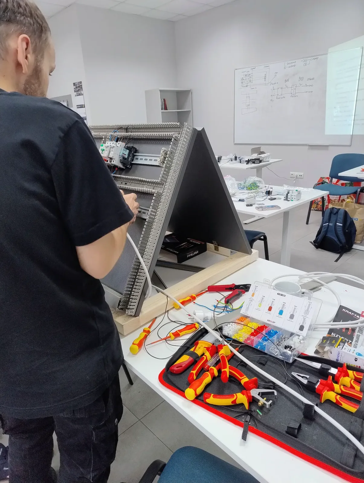Isolierte Werkzeuge und Komponenten für eine elektrotechnische Übung.